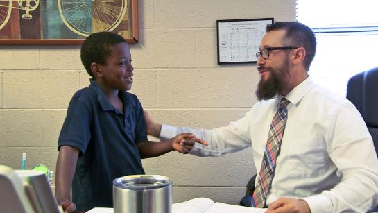 teacher speaking with young student
