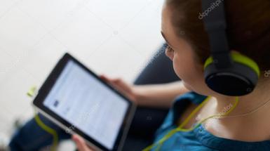 woman listening to podcast on pad